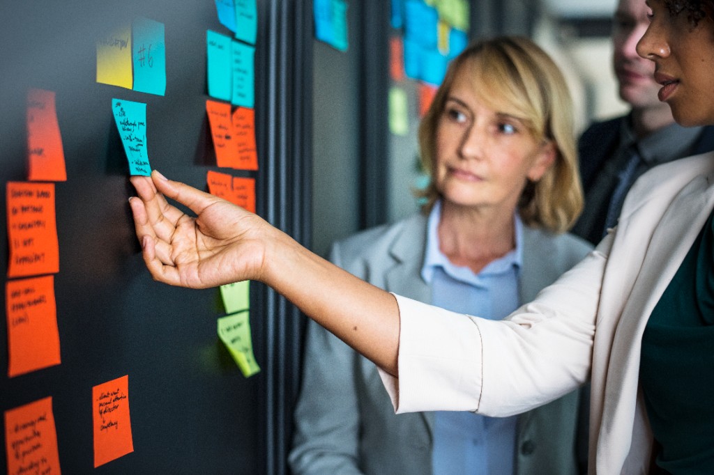 Time planejando tarefas com post-its em um quadro
